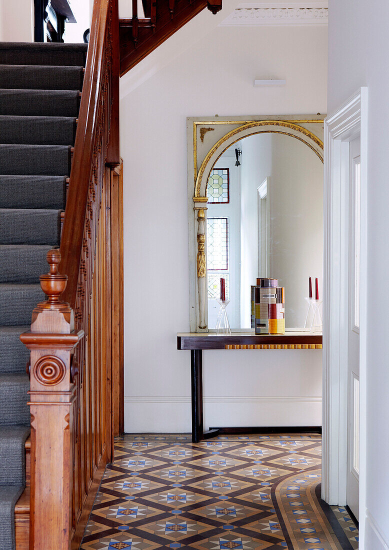 Gewölbter Spiegel in einem gefliesten Flur mit Holzgeländer in einem Londoner Haus