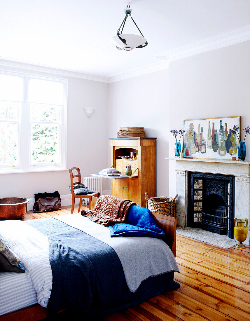 Sunlit bedroom with original fireplace in London home