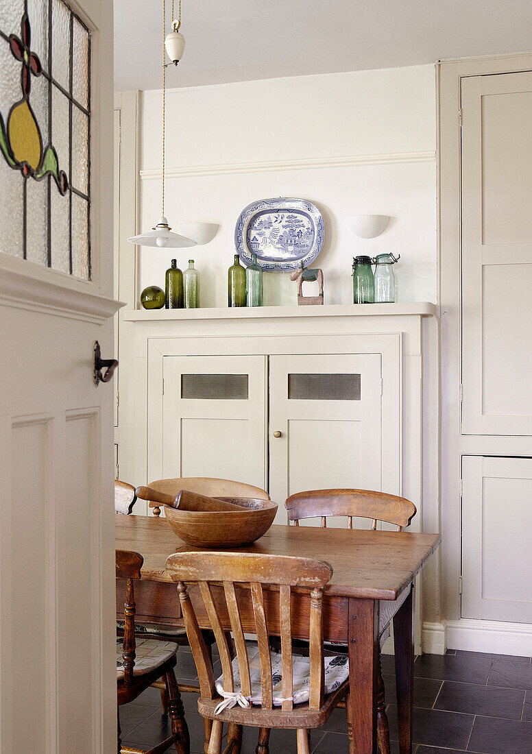 Holztisch und -stühle in der cremefarbenen Küche eines Landhauses