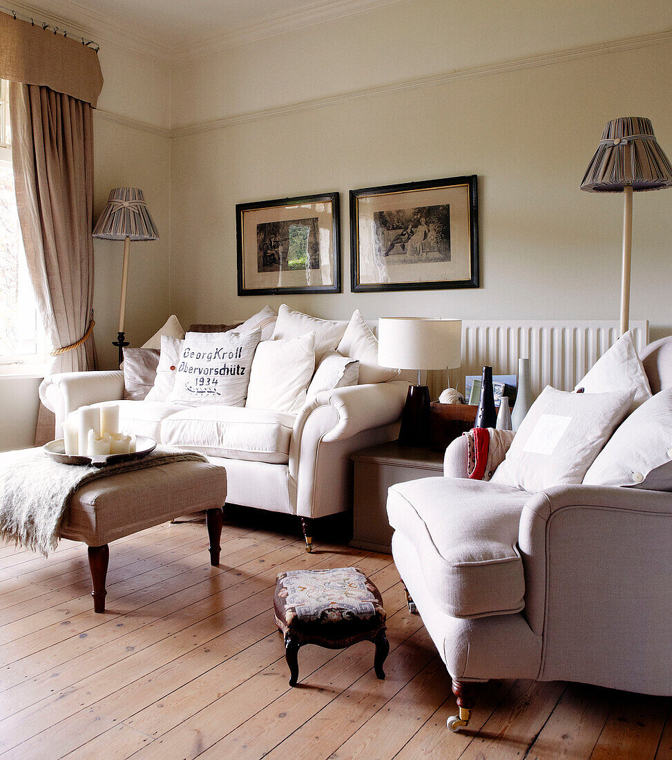 White two seater sofa and armchair in living room of country home