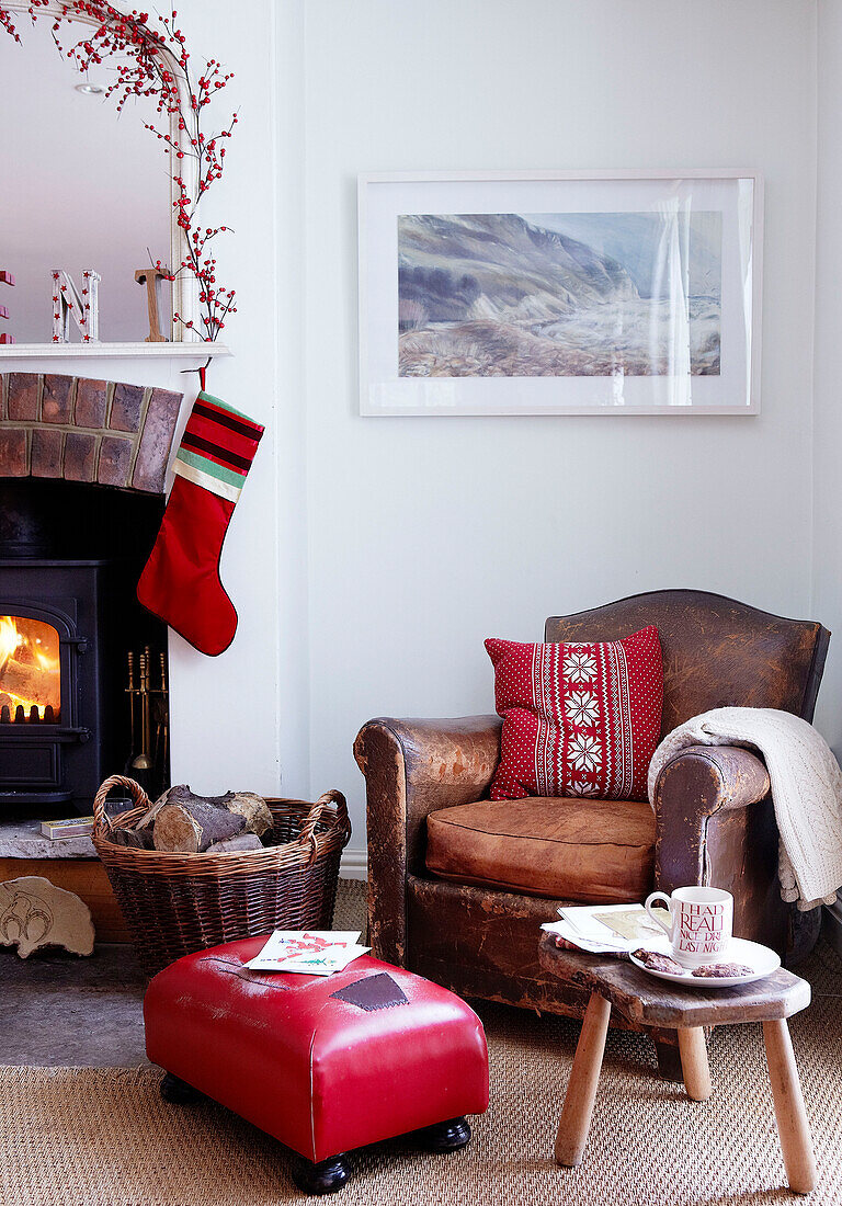Brown leather armchair at fireside with Christmas stocking