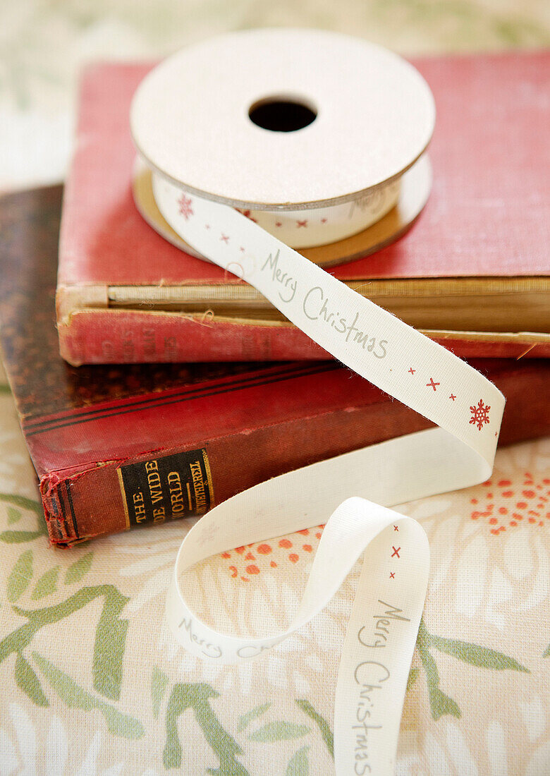 Christmas ribbon on red hard-backed books