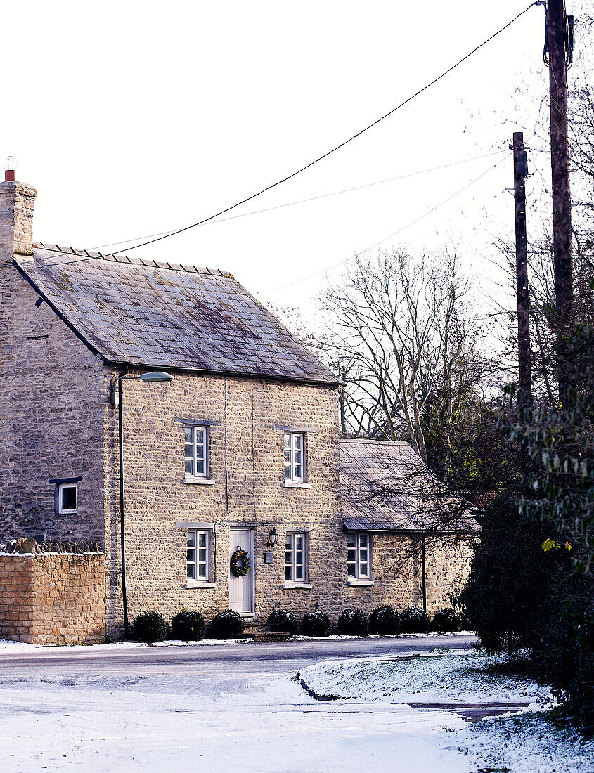 Landhaus aus Stein in einem Dorf mit Schneefall
