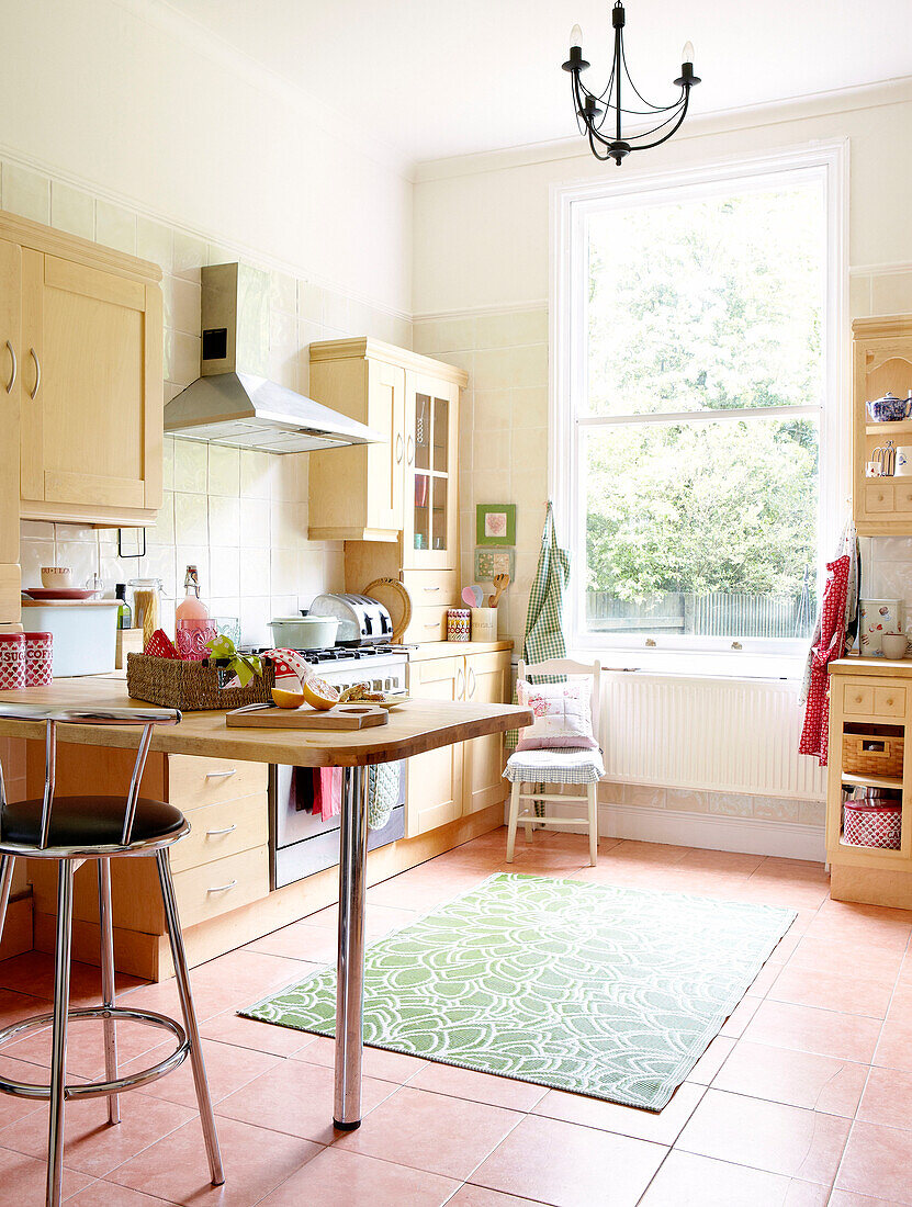 Sunlit family kitchen with bar stool at breakfast bar