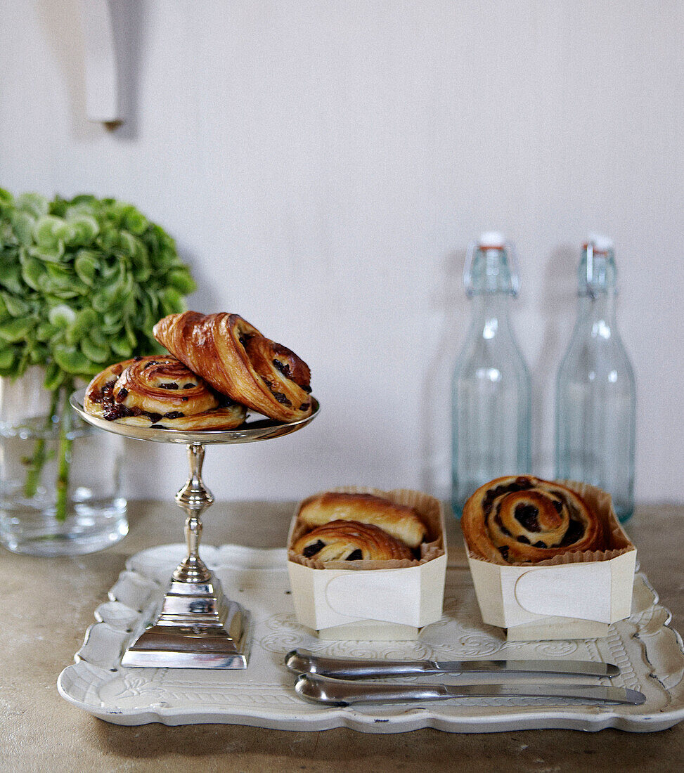 Danish pastries on tray with knives in country home