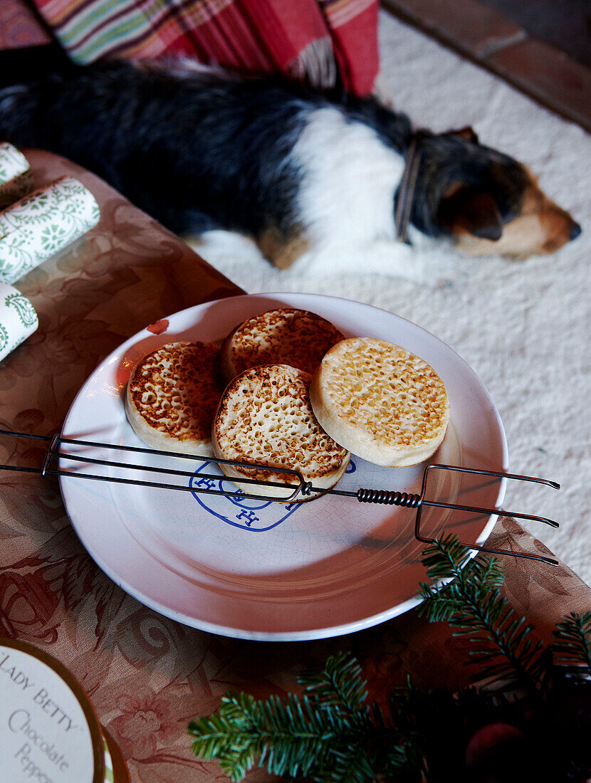 Crumpets und Toasting-Gabel mit schlafendem Hund