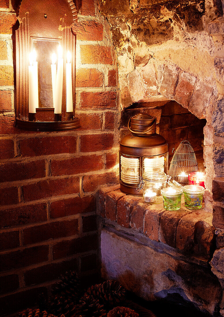 Lit candle and lanterns on exposed brick interior