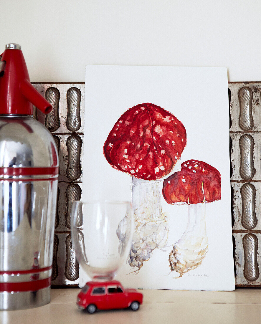 Silver homeware and mushroom artwork with small red toy car