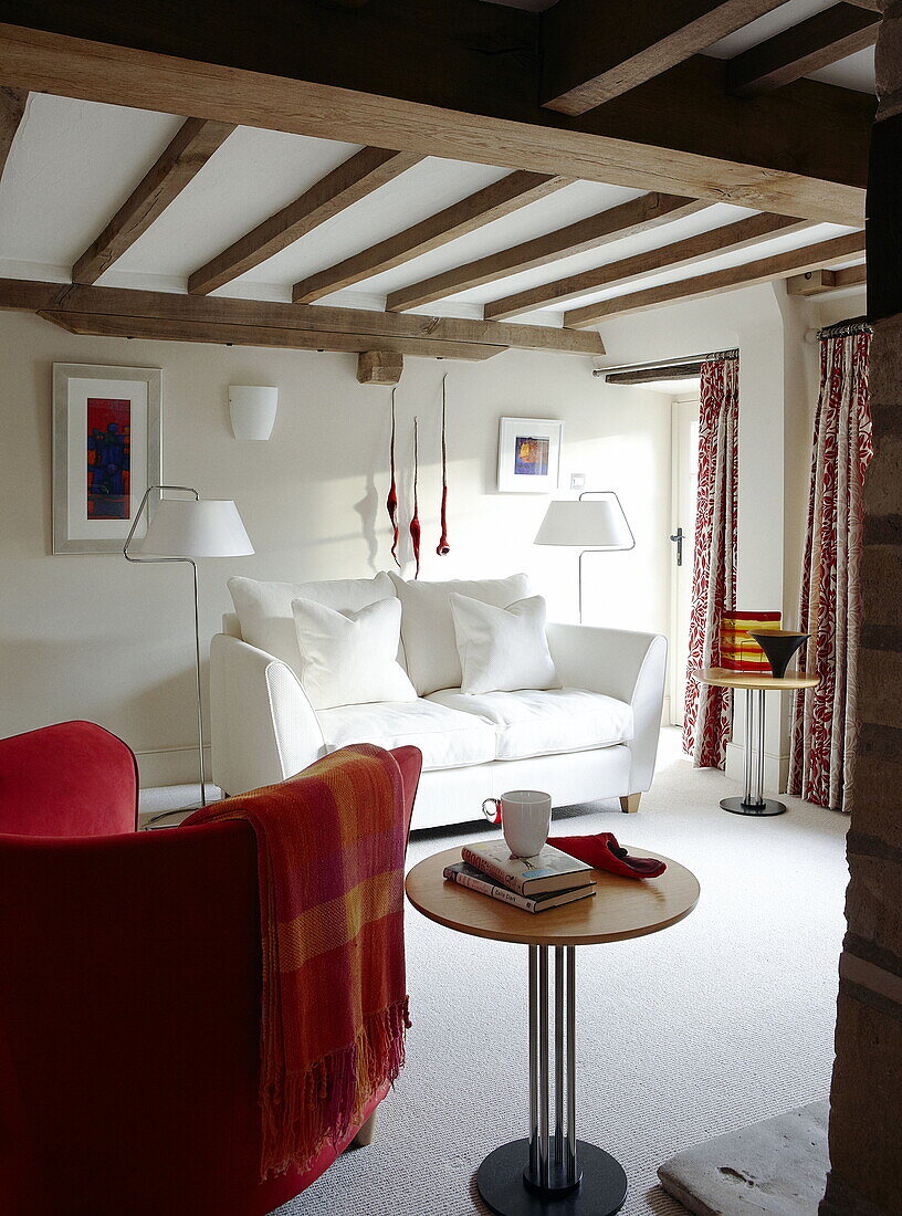 White sofa in beamed living room renovated Cotswolds mill house England UK