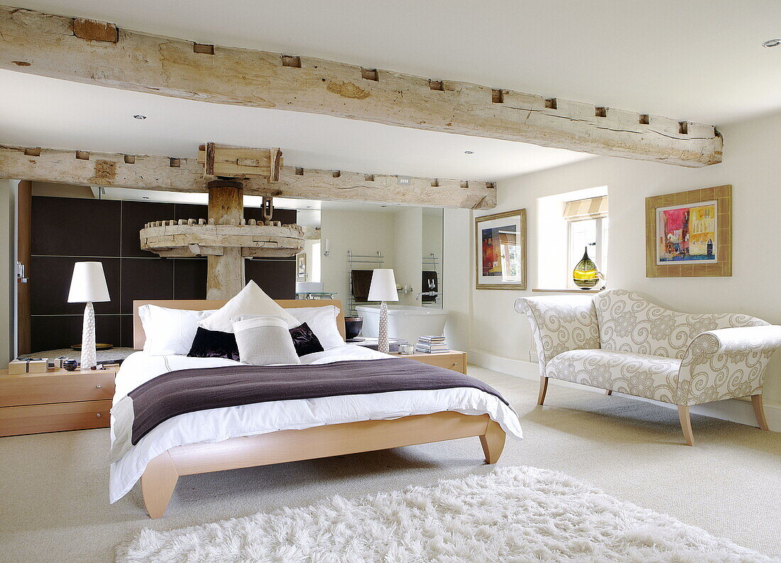 Double bed with original mechanism for grinding flour in renovated Cotswolds mill house England UK