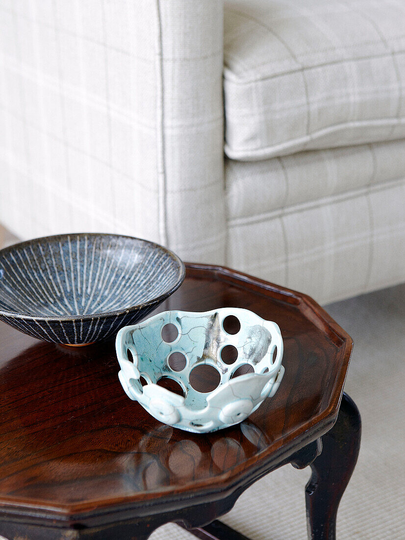 Two bowls on polished wooden side table in living room of Hampshire home England UK