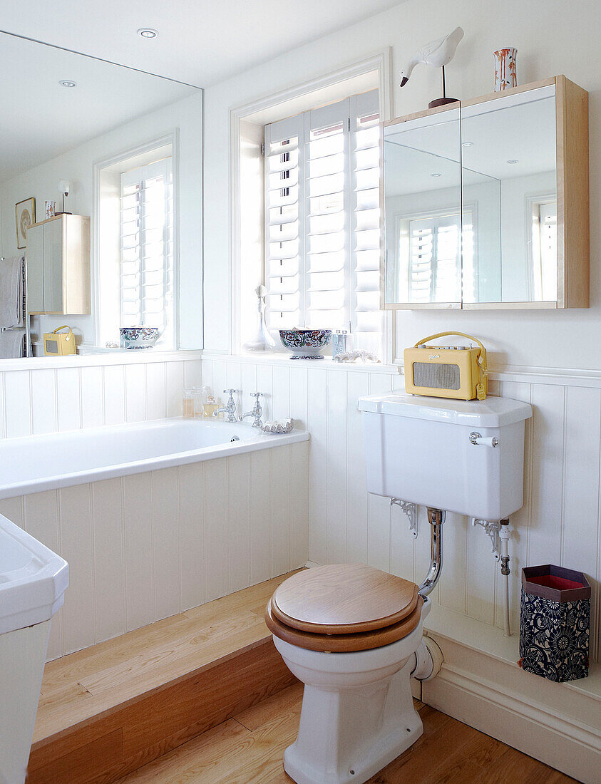 Ebenerdiges Badezimmer mit Jalousien und Spiegeln, die das Licht reflektieren Haus in Hampshire, England, UK