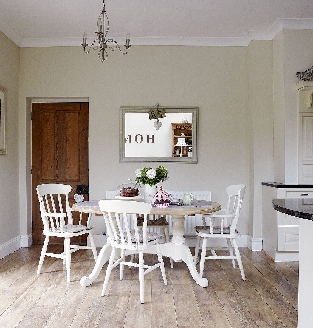 White painted chairs at table in dining room of Gateshead apartment Tyne and Wear England UK