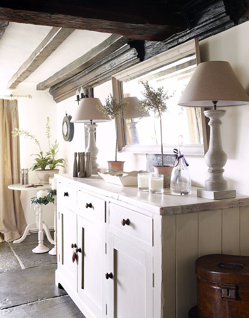 Matching lamps on painted sideboard in timber framed Forest Row farmhouse Surrey England UK