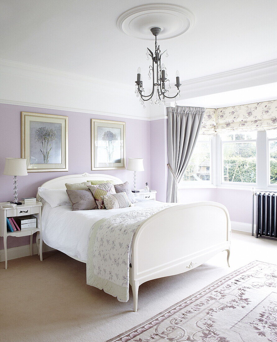 Weißes Doppelbett im fliederfarbenen Schlafzimmer eines Hauses in Harrogate, Yorkshire, England UK