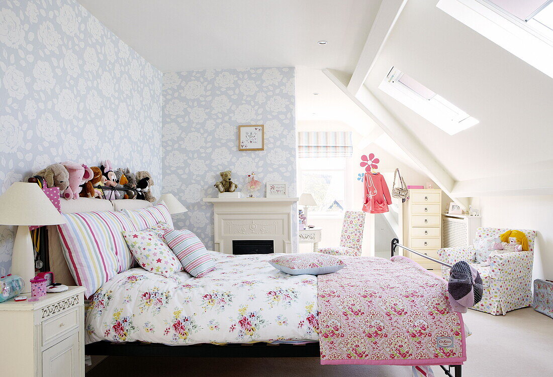 Contrasting floral patterns in teenage girl's bedroom attic conversion in Harrogate home Yorkshire England UK