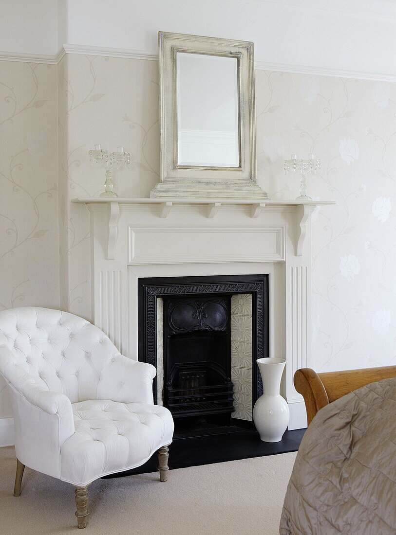 Buttoned armchair at fireplace of Harrogate home Yorkshire England UK