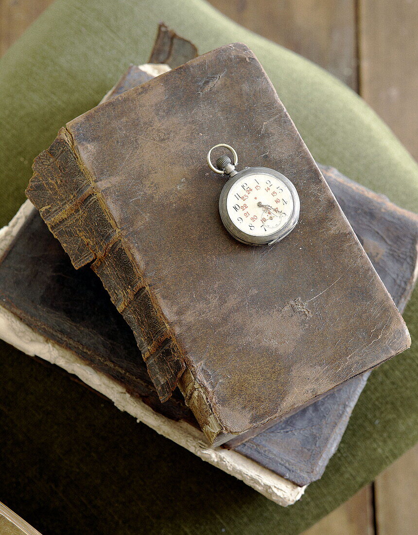 Vintage-Taschenuhr auf altem Lederbuch im Haus Abbekerk in der niederländischen Provinz Nordholland, Gemeinde Medemblik