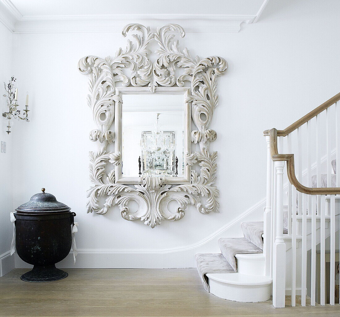 Dekorativer Spiegel im Treppenhaus mit schwarzer Urne und blattgeschwungenem Rahmen London home UK