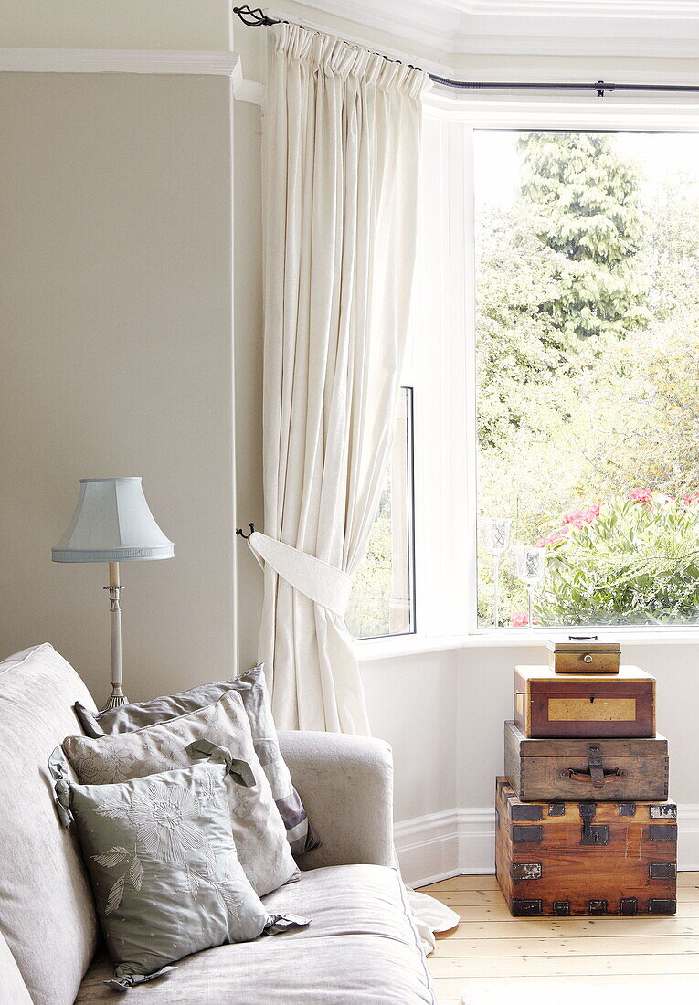 Embroidered cushions on sofa with wooden storage boxes in Gateshead living room Tyne and Wear England UK