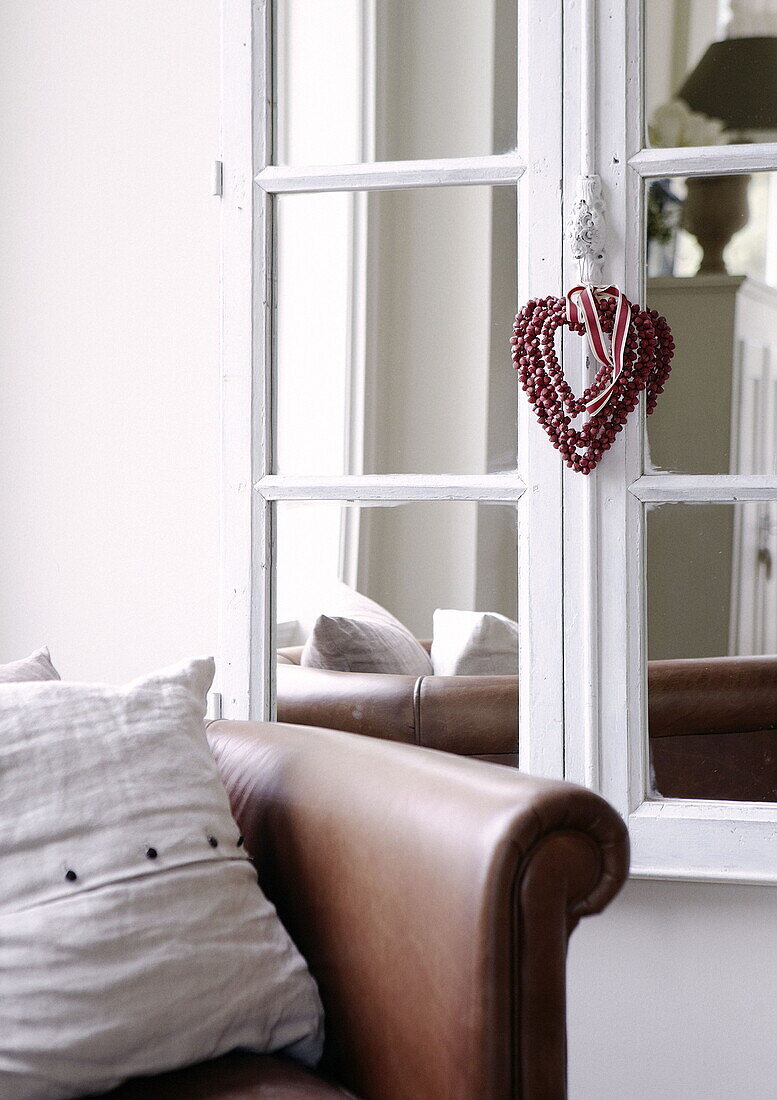 Herzförmiges Ornament hängt an einem alten Fensterspiegel in einem Landhaus in Tunbridge Wells, Kent, England UK