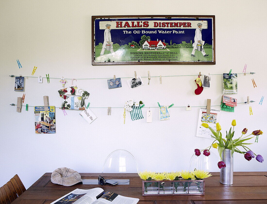 Vintage-Kunstwerk und Wäscheleine hängen über dem Küchentisch in einem Einfamilienhaus London UK