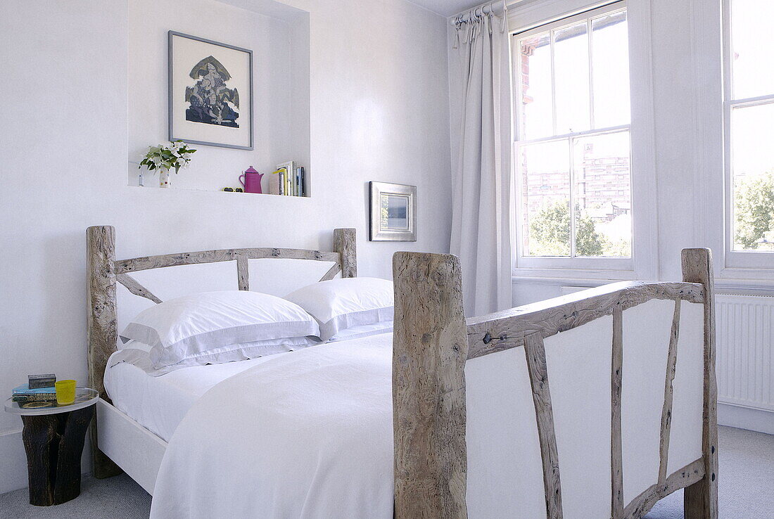 Alkovenregal über einem Doppelbett aus wiederverwertetem Holz in einem Familienhaus in London, UK