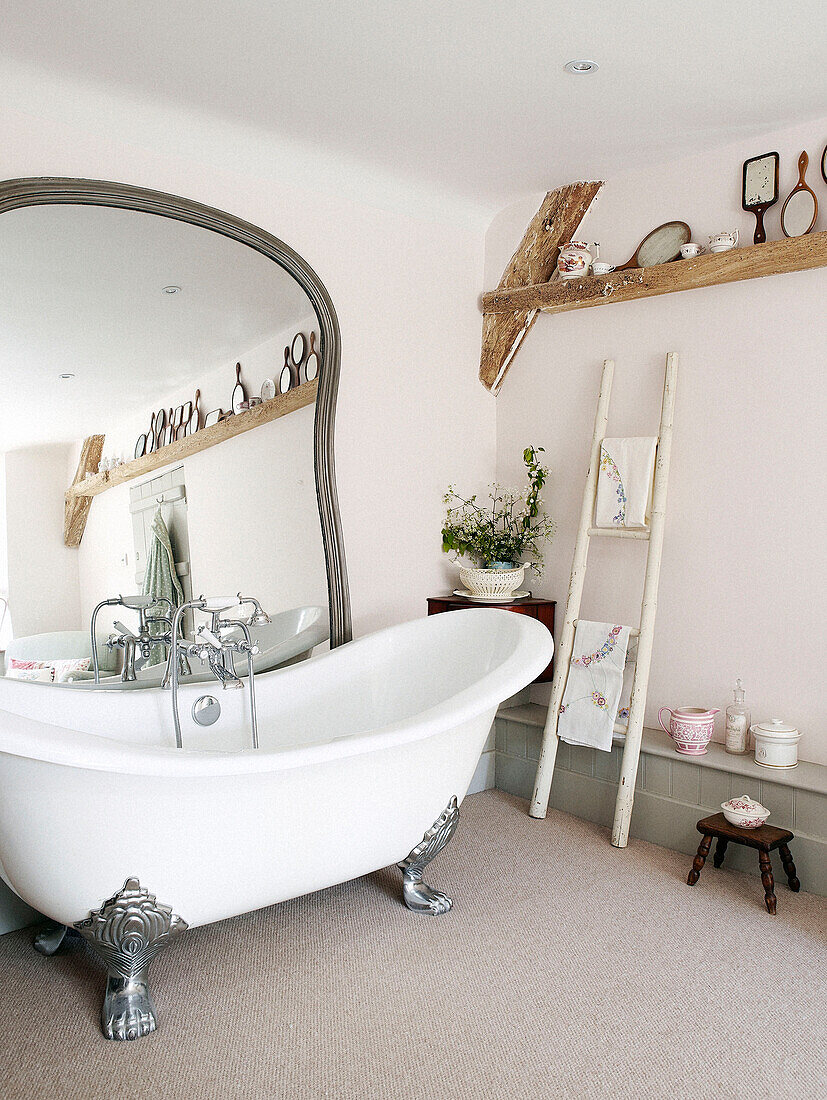 Großer Spiegel mit Klauenfußbadewanne in einem Bauernhaus in Oxfordshire, England, UK