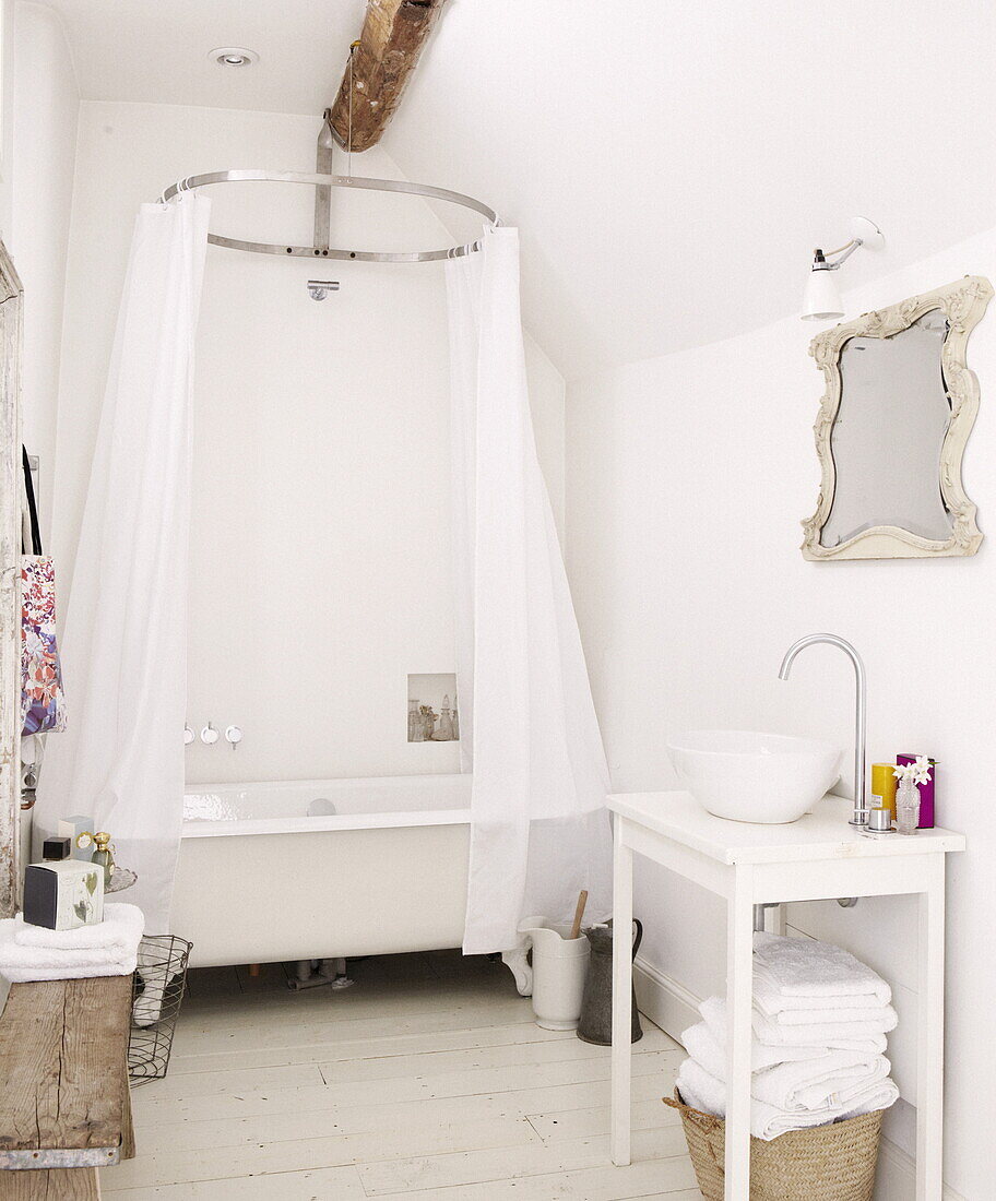 Freistehende Badewanne mit Duschvorhang im Badezimmer eines modernen Cottages in Oxfordshire, England, UK