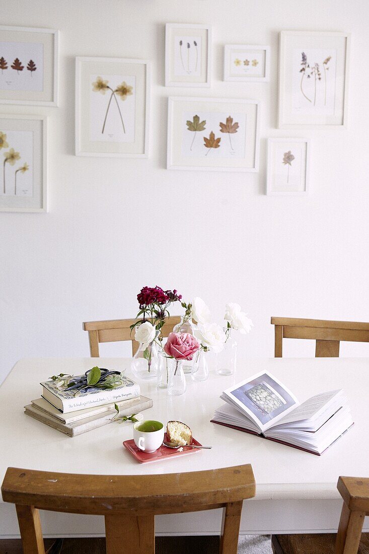 Pressed flowers in frames on dining room wall of contemporary cottage in Staffordshire home, England, UK