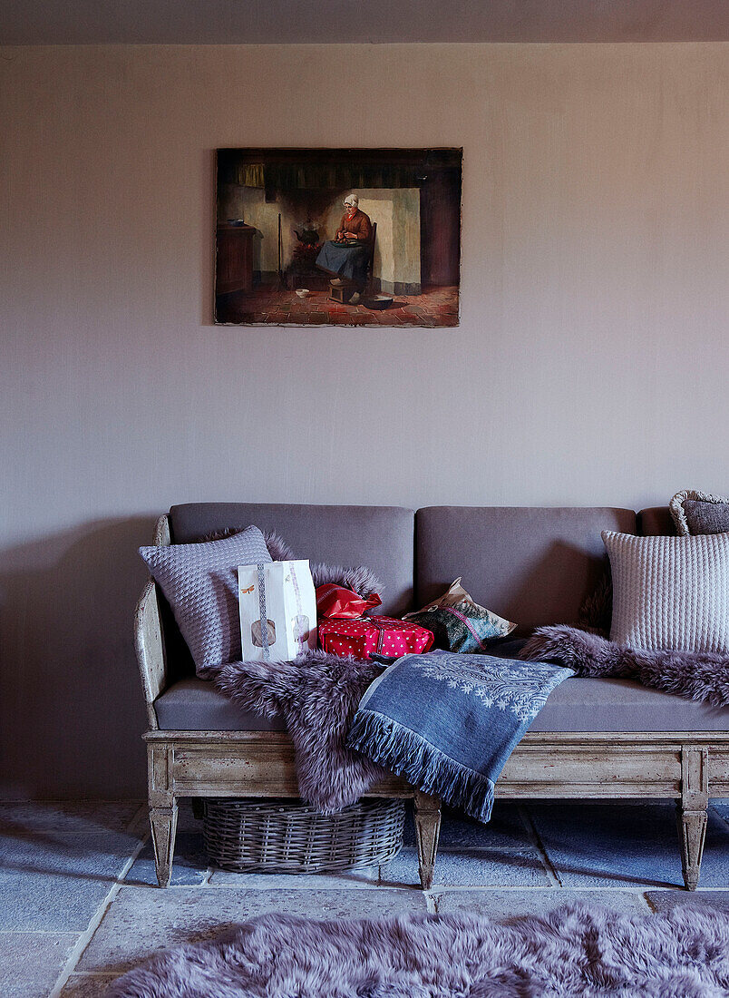 Wolldecken auf antikem Sofa unter Kunstwerken in einem festlichen Haus in Oxfordshire, England, UK