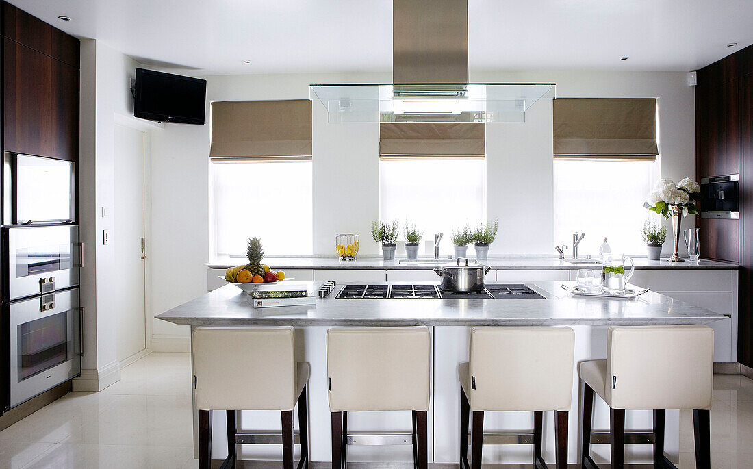 Barhocker aus weißem Leder in der klassischen Küche eines luxuriösen Hauses in London, England, Vereinigtes Königreich