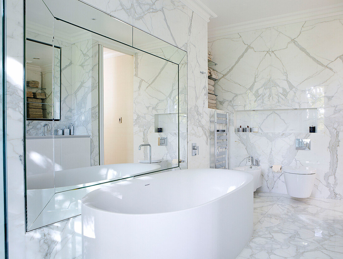 Großer Spiegel über freistehender Badewanne im Marmorbad eines luxuriösen Hauses in London, England, UK