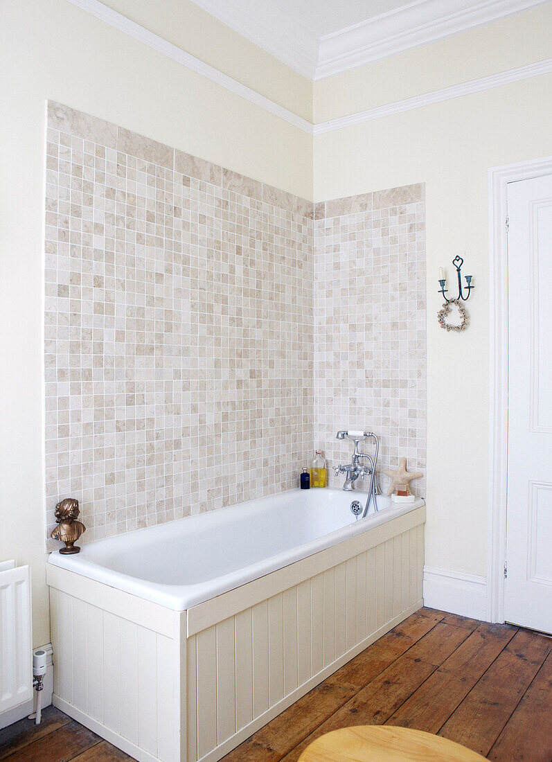 Tiled bathroom with wooden floor in Warwickshire home, England, UK