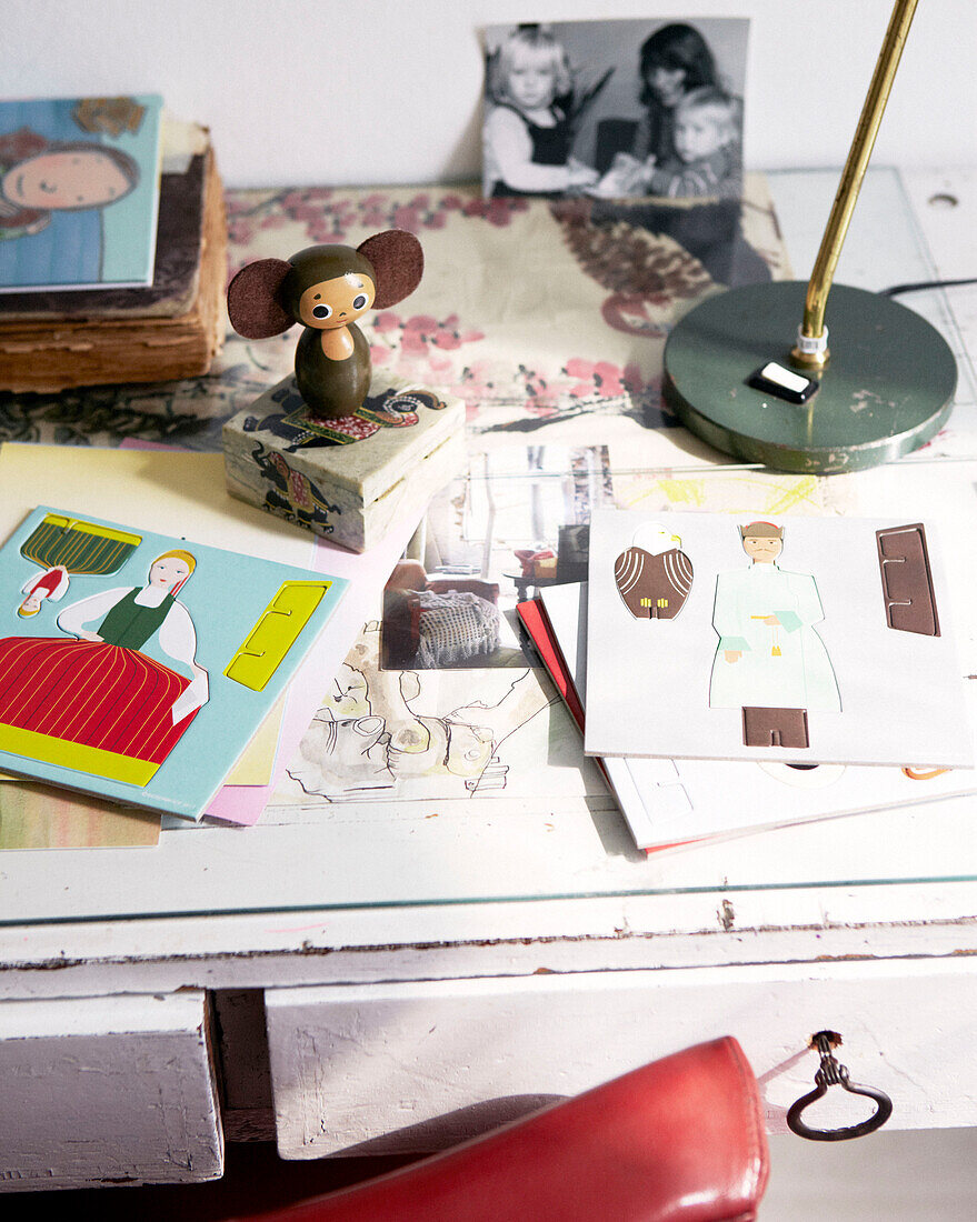 Ausgeschnittenes Buch mit Mausfigur und Familienfoto auf dem Schreibtisch in einer modernen Wohnung, Amsterdam, Niederlande