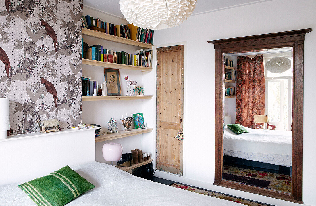 Bauschutt in einem modernen Schlafzimmer mit Bücherregalen und gemusterter Tapete, Amsterdam, Niederlande
