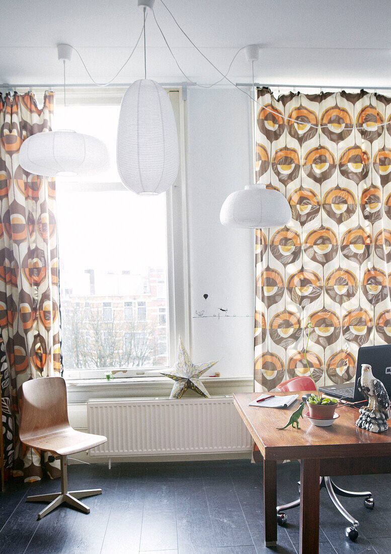 Vorhänge und Holzmöbel im Stil der 1960er Jahre in einer Wohnung mit Pendelleuchten mit Papierschirmen, Amsterdam, Niederlande