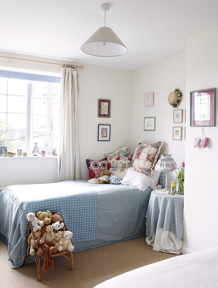 Einzelbett mit blauer Decke am Fenster im Kinderzimmer, Oxfordshire, England, UK