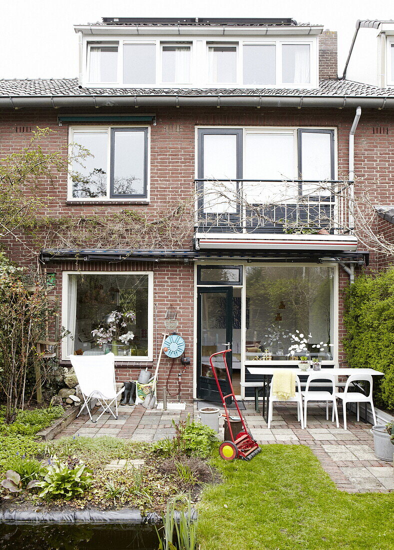 Rasenmäher im hinteren Garten einer Doppelhaushälfte mit ausgebautem Dachgeschoss in Bussum, in der Nähe von Amsterdam, Niederlande