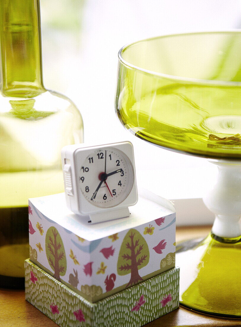Alarm clock on notepad with coloured glassware in Bussum home, Netherlands