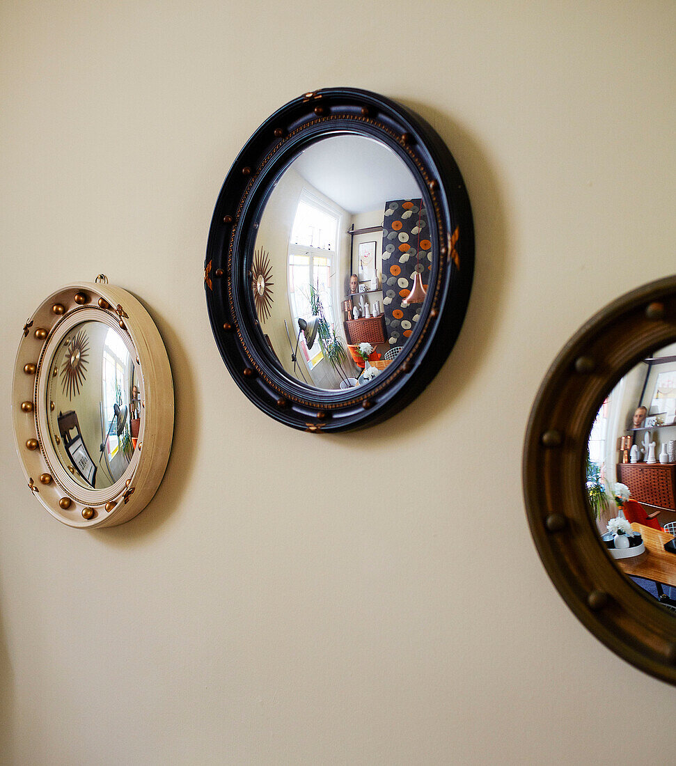 Three convex mirrors in living room of family home in Margate Kent England UK