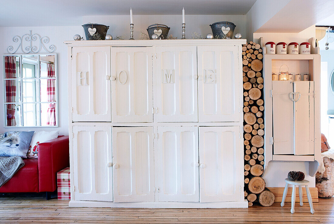 "Bemalter Schrank mit dem Schriftzug HOME"" und Holzscheiten in einem Bauernhaus in Derbyshire, England, UK"""
