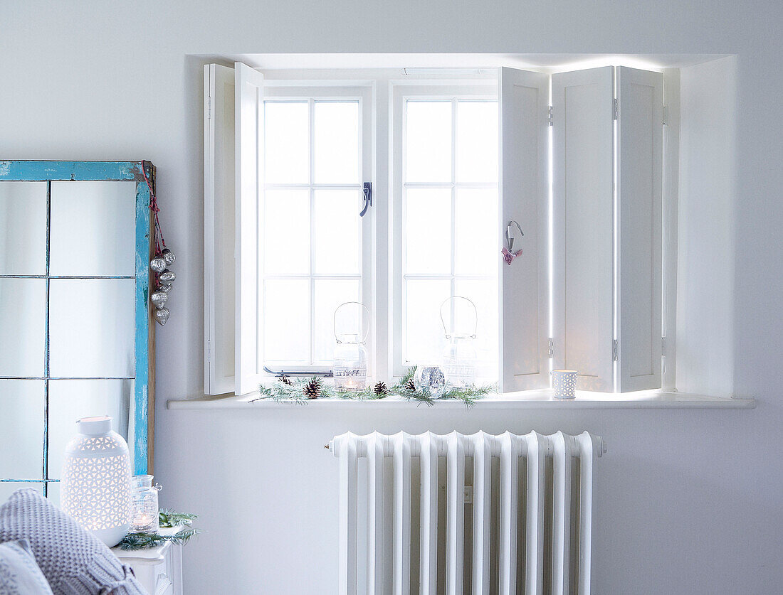 White window shutters above radiator in Devonshire country home UK