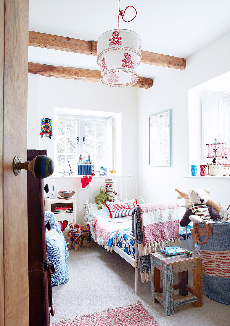 Einzelbett in einem Kinderzimmer mit Balken in einem Landhaus in Devonshire UK