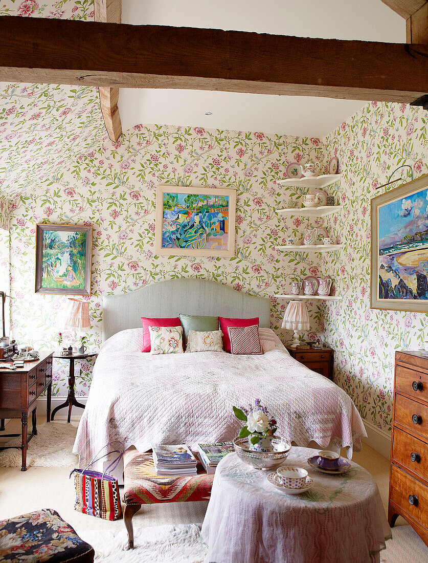 Doppelbett mit Blümchentapete in einem Landhaus in Oxfordshire, England