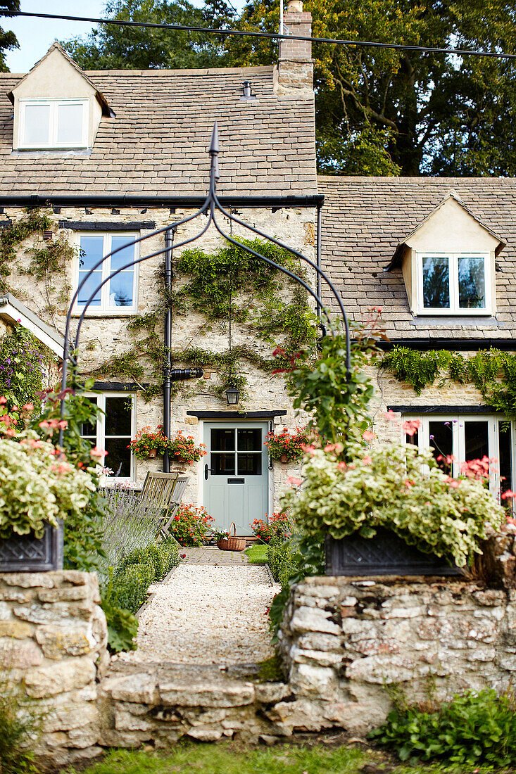 Wrought iron archway and front path to rural Oxfordshire cottage England UK