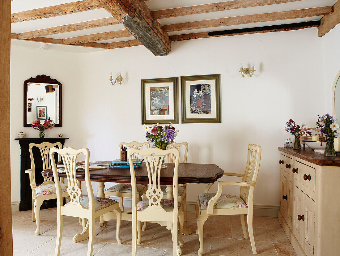 Esstisch mit bemalten Stühlen in einem Cottage mit Balken in Oxfordshire, England UK