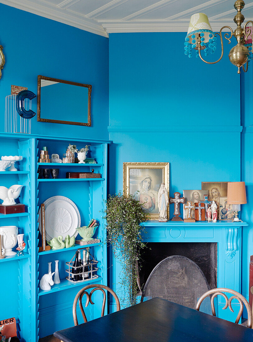 Collection of religious icons and chinaware on bright blue shelving in Auckland home North Island New Zealand