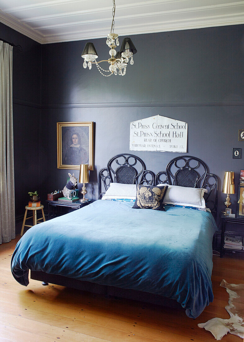 Blaue Decke mit goldgerahmtem Kunstwerk und Lampe in einem Schlafzimmer in Auckland auf der Nordinsel Neuseelands