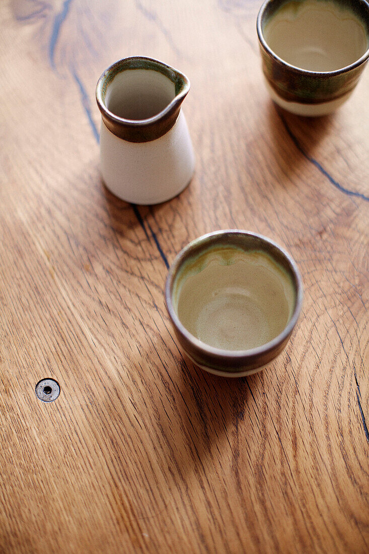 Keramikkanne und Tassen auf hölzerner Arbeitsplatte in einem Haus in Notting Hill, West London UK